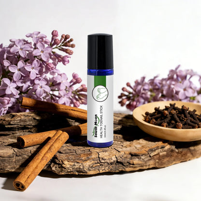 Herbal toenail treatment stick with lilac flowers, cinnamon sticks, and cloves on wood