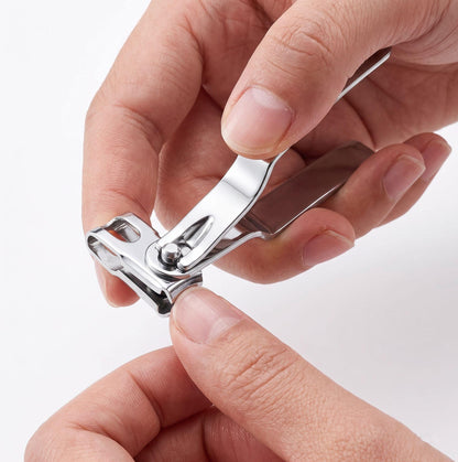 Close-up of a hand using a high-quality stainless steel fingernail clipper with integrated nail file to trim a fingernail for clean, precise cuts